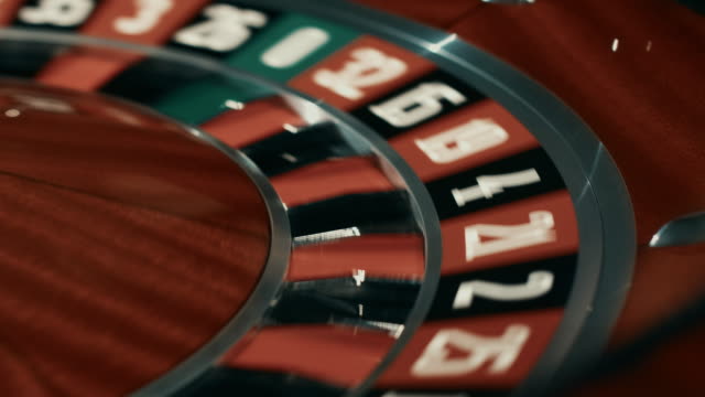 Wooden-roulette-wheel-with-black-and-red-sectors.-Close-up-white-ball-stopped