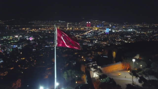 city-​​skyline-drawn-by-night-drone,--city-​​skyline-flag-in-front-of-kadifekale,-izmir
