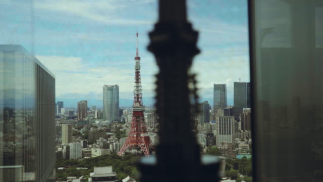Beautiful-revealing-shot-of-a-Tokyo-tower-surrounded-with-skyscrapers-on-a-summer-day.