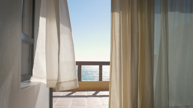 Cortinas-blancas-en-un-Resort-frente-al-mar-que-sopla-una-brisa-de-verano---cámara-lenta