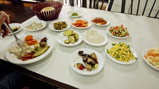 Timelapse-del-hombre-comer-comida-árabe,-Hummus-y-ensaladas-en-un-restaurante
