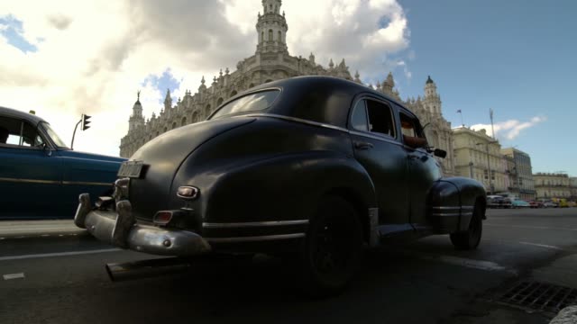 Viejos-coches-americanos-clásicos-pasando-por-las-calles-de-la-ciudad-de-la-Habana,-Cuba