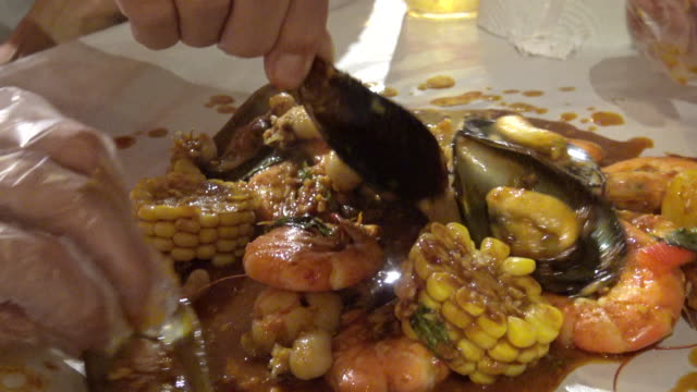 Meeresfrüchte-Eimer-Kochen-in-New-Orleans-Gewürz-Sauce-Essen-mit-Hand-4k