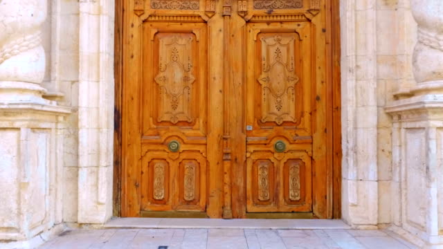 Entrance-with-a-big-wooden-door-in-beautiful-ancient-church-with-twisted-columns