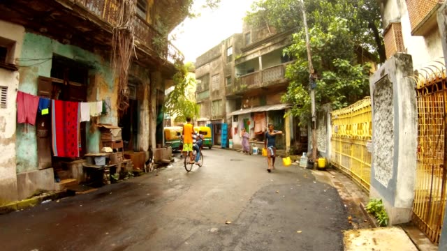 alte-Straße-schäbige-Gebäude-bengalis-Menschen-gehen-tragen-Wasser-Schulmädchen-Jungen-Reiten-Fahrrad-Kolkata
