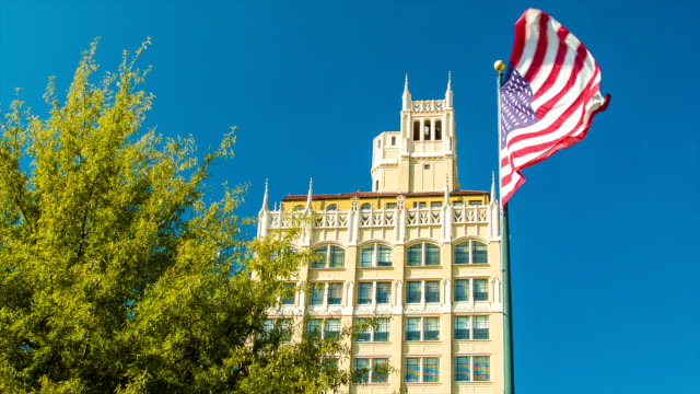 El-centro-de-Asheville,-Carolina-del-Norte,-arquitectura-con-bandera-estadounidense-y-cielo-azul