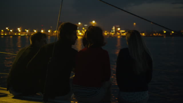 Gruppe-von-Menschen,-die-sich-nachts-auf-einer-Yacht-im-Meer-entspannen.