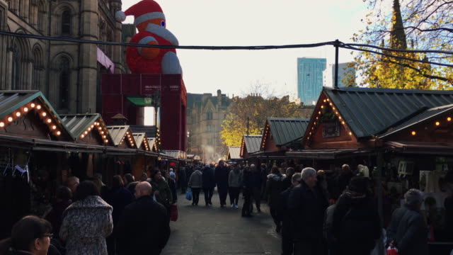 MANCHESTER,UK---DECEMBER-16,-2016.-Shot-of-shoppers-at-the-Christmas-market-in-front-of-the-Manchester-Town-Hall-on-Albert-Square.-December-16,-2016