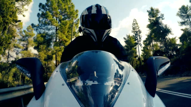 Tiro-POv-de-un-hombre-montado-en-una-motocicleta-de-deportivo-de-color-blanco-en-una-carretera-de-curva