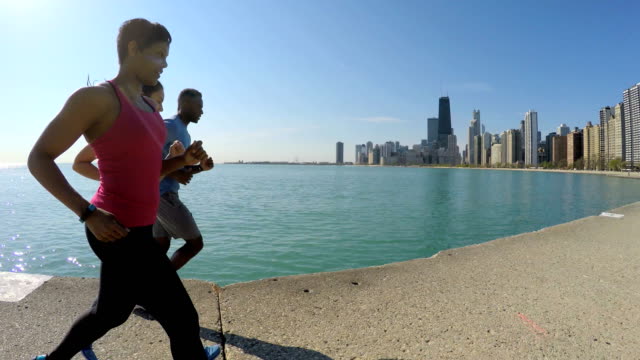 Multi-étnica-americana-amigos-corriendo-por-el-lago-Michigan
