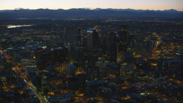 Aerial-view-of-Denver-at-night-with-Rocky-Mountains-in-background