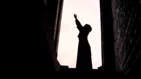 Young-muslim-woman-in-hijab-praying-in-abandoned-building,-scared-and-worried