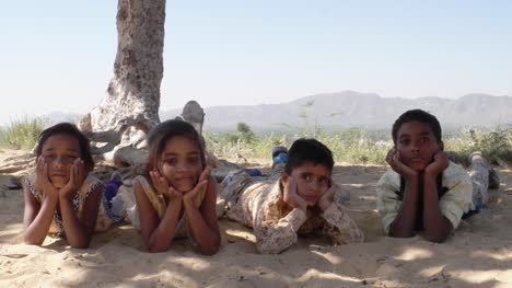 Indian-children-portrait-happy-and-excited,-playing-and-making-merry-in-sand-area-in-Rajasthan-state-of-India