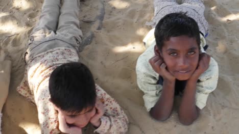 Indian-children-portrait-happy-and-excited,-playing-and-making-merry-in-sand-area-in-Rajasthan-state-of-India