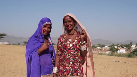 Pan-links-nach-zwei-Freundinnen-im-traditionellen-Rajasthani-Kleider-mit-Spaß-und-schaut-in-die-Kamera