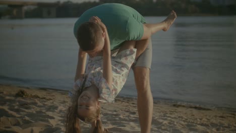 Glücklicher-Vater-Spaß-mit-Tochter-am-Strand