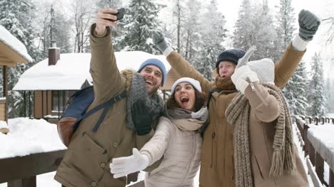 Grupo-de-amigo-tomando-Selfie-en-bosque-del-invierno