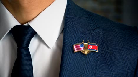 Geschäftsmann-zu-Fuß-in-Richtung-Kamera-mit-Freund-Land-Flaggen-Pin-Vereinigte-Staaten-von-Amerika---Nord-Korea.mov