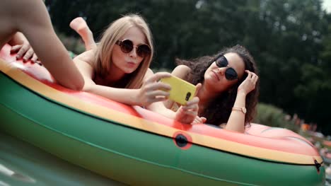Group-of-friends-making-selfies-on-water-mat-floating-on-the-lake.
