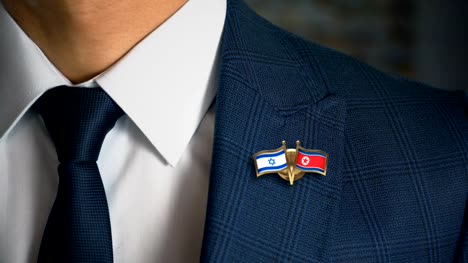 Geschäftsmann-zu-Fuß-in-Richtung-Kamera-mit-Freund-Land-Flaggen-Pin-Israel---Nordkorea