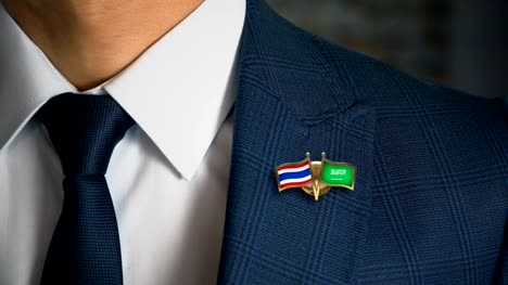 Businessman-Walking-Towards-Camera-With-Friend-Country-Flags-Pin-Thailand---Saudi-Arabia