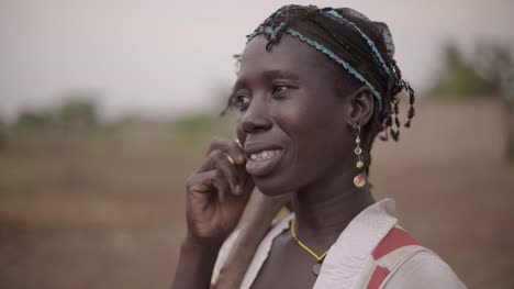 Porträt-einer-jungen-afrikanischen-Bäuerin,-die-spontan-auf-ihrem-Handy-spricht