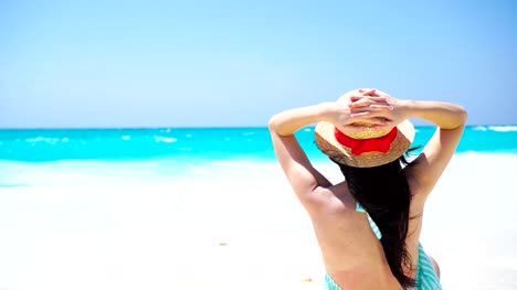 Vista-trasera-de-la-hermosa-mujer-en-sombrero-en-las-vacaciones-de-verano-en-la-playa-blanca.