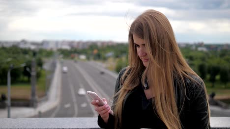 Junge-Frau-nutzt-eine-Smartphone-und-glättet-Haare