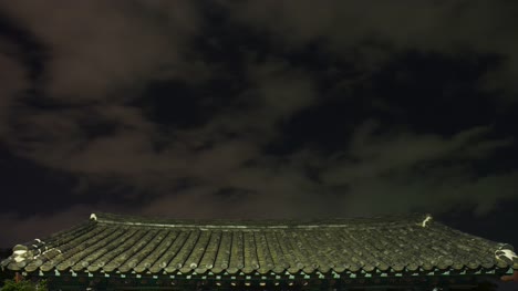 Escena-de-techo-de-casa-antigua-Gyeongju,-Corea-por-la-noche-en-las-nubes-en-movimiento