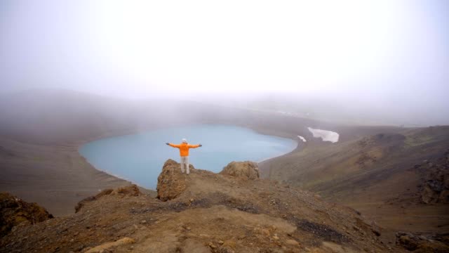 4K-video---Young-woman-arms-outstretched-at-spectacular-crater-lake-in-Iceland