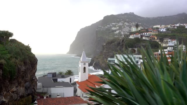 View-of-São-Sebastião-church-with-Cape-Girão,-in-Câmara-de-Lobos,-Madeira