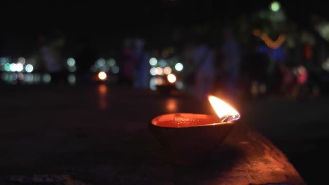 Lámpara-de-aceite-tierra-India-tradicional-con-mecha-de-algodón-ardiendo-en-el-lago-de-Pushkar
