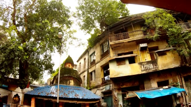 edificios-en-mal-estado-cubiertos-de-árboles-antigua-calle-de-Kolkata-techo-de-templo-hindú