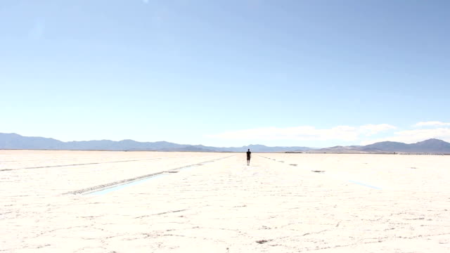 Man-in-Distance-Walking-Away-On-Salt-Flats