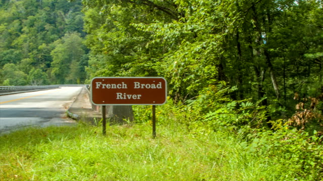Forests-Against-French-Froad-River-in-Asheville,-NC-with-Traffic