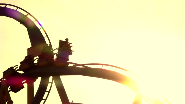 CLOSE-UP:-Friends-on-extreme-roller-coaster-ride-at-sunset