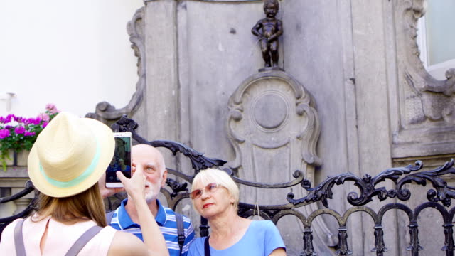Tochter-nehmen-Foto-ihrer-älteren-Eltern-auf-Urlaubsreise-in-Brüssel.-Glückliche-Familie-Urlaub-genießen