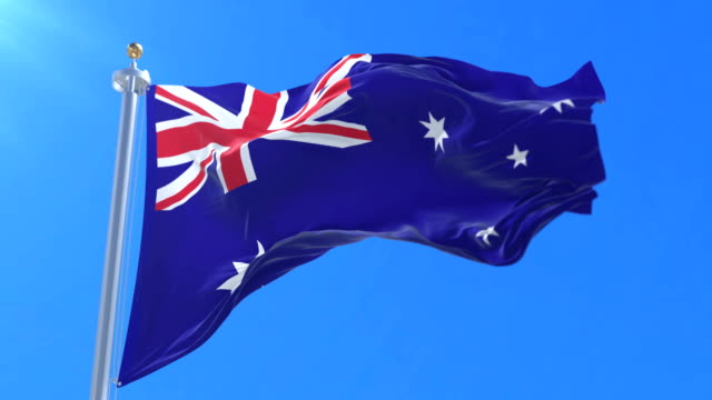 Flag-of-Australia-waving-at-wind-in-blue-sky,-loop