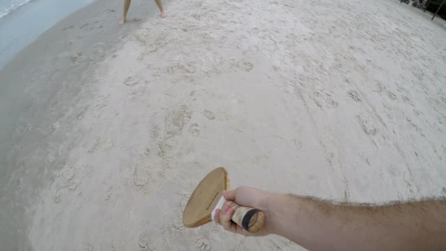 Paar-Frescobol-am-Strand-spielen