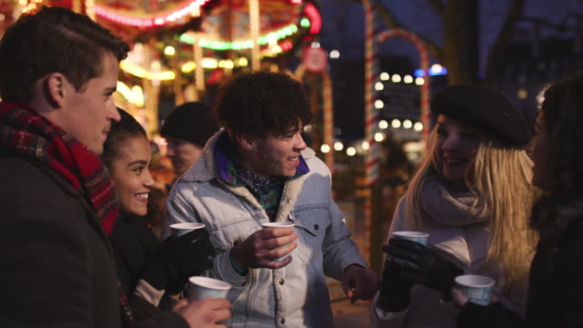 Group-Of-Friends-Drinking-Mulled-Wine-At-Christmas-Market