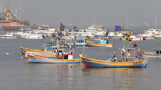Barcos-de-pesca-madera-y-costosos-yates-en-el-agua-de-mar,-Mumbai,-India