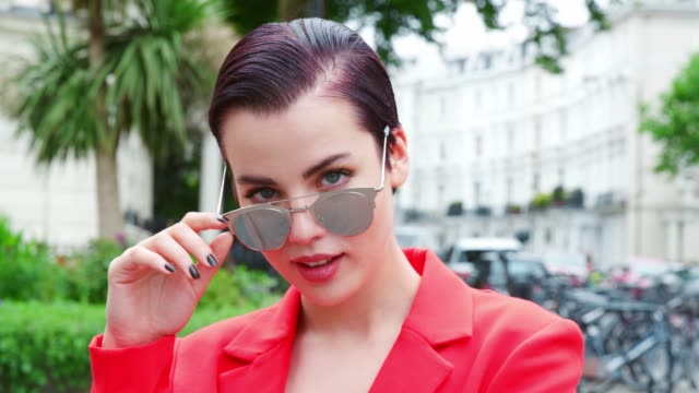 Stilvolle-Frau-mit-Sonnenbrille-auf-Stadtstraße-stehend