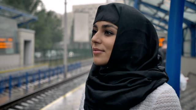Young-dreaming-muslim-woman-in-hijab-is-waiting-for-train,-religion-concept,-urban-concept