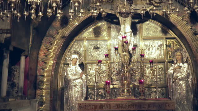 tilt-down-shot-of-the-crucifixion-site-and-a-kneeling-woman-praying-in-the-church-of-the-holy-sepulchre