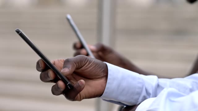 black-men's-hands-typing-on-smartphones.