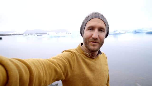 Junger-Mann-nehmen-Selfie-mit-Gletschersee,-Eisberge-schwimmt-auf-Wasser-in-Island
