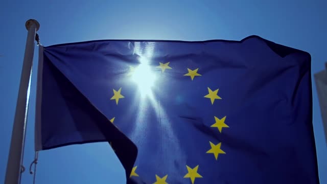 Waving-European-Union-flag-in-the-wind-with-a-blue-sky.