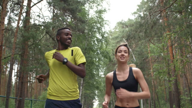 Cheerful-Man-and-Woman-Jogging-in-Forest
