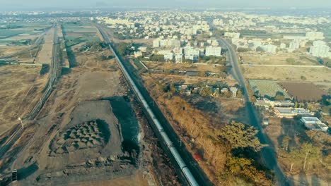 Establishing-drone-shot-of-a-passenger-train-moving-into-an-Indian-city