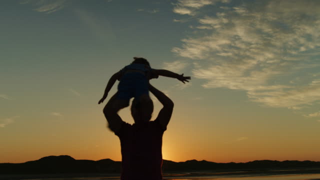 Silhouette-Of-Father-And-Son-Playing-Together-At-The-Beach.